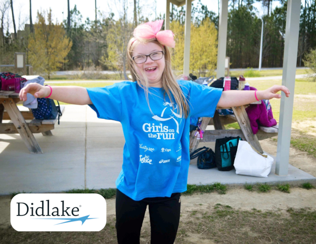 Girls on the Run participant smiling with her arms outstretched. 