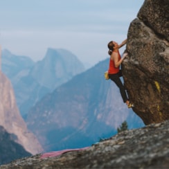 Woman rock climbing a mountain.